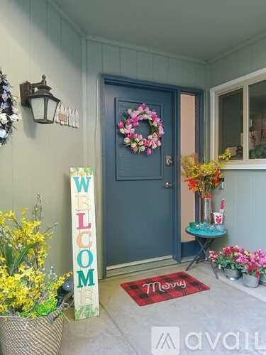 A blue door with a wreath and a sign that says "Welcome".
