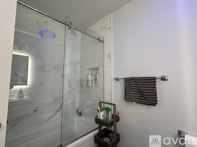 A kitchen with a black counter top and grey cabinets.