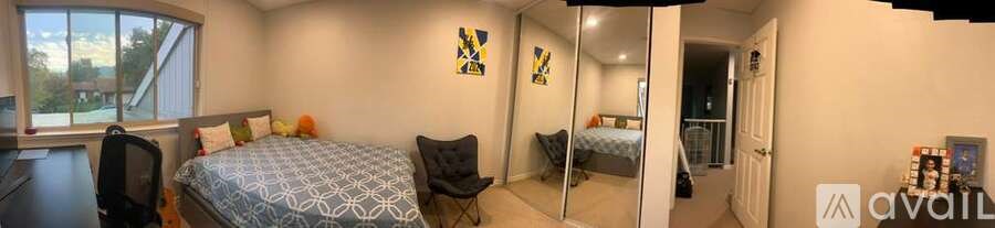 A bedroom with a bed, chair, and mirror.