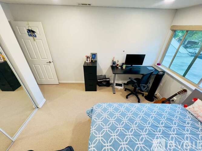 A bedroom with a bed, desk, and chair.