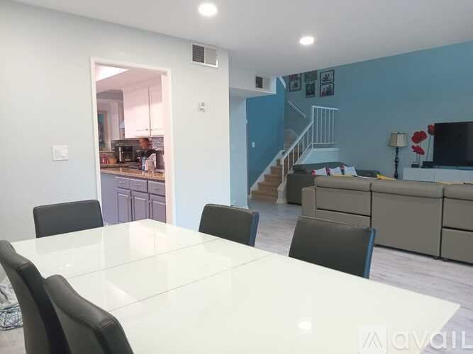 A white dining table with four chairs in a room.