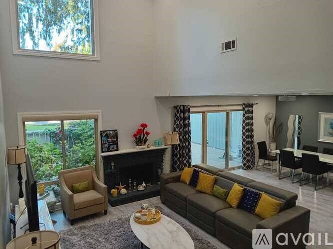 A living room with a grey couch and a fireplace.