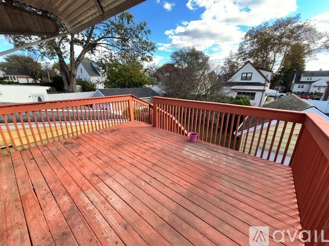 A wooden deck with a railing and a purple object on it.