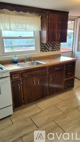 A kitchen with wooden cabinets and a white dishwasher.