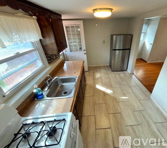 A kitchen with a stove, sink, and refrigerator.