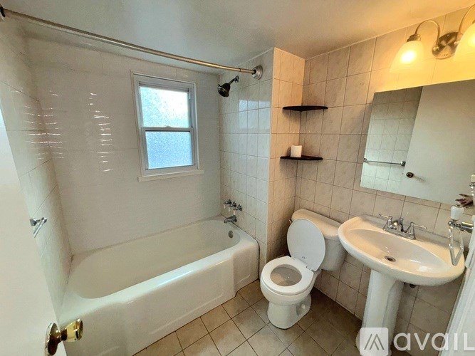 A bathroom with a white tub, toilet, and sink.