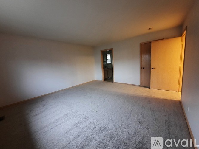 A room with a carpeted floor and a wooden door.