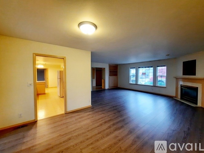 A spacious living room with hardwood floors and a fireplace.