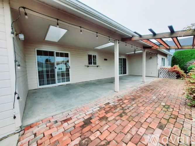 A patio area with a brick walkway and a pergola.