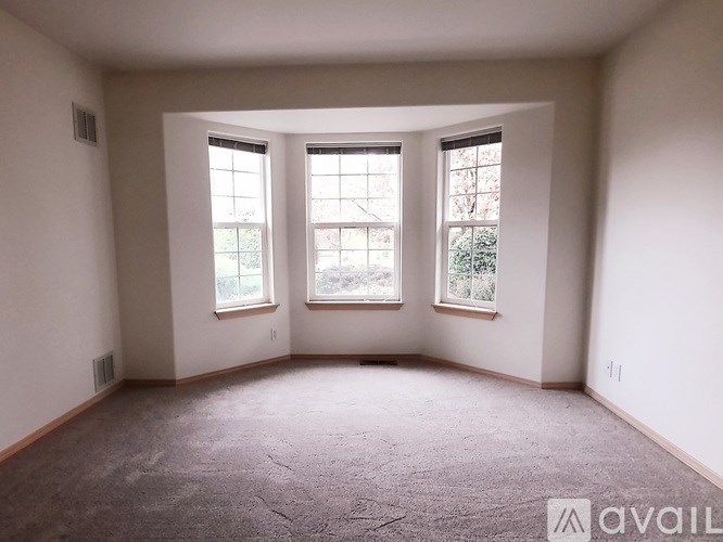 A room with a carpeted floor and two wooden doors.