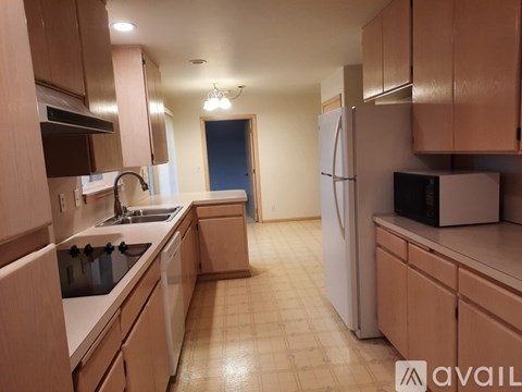 A kitchen with wooden cabinets and a white refrigerator.