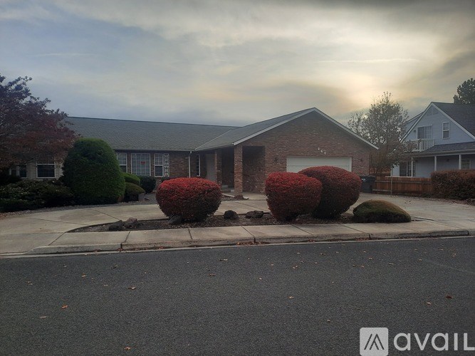 A cloudy day at a residential area with houses and bushes.