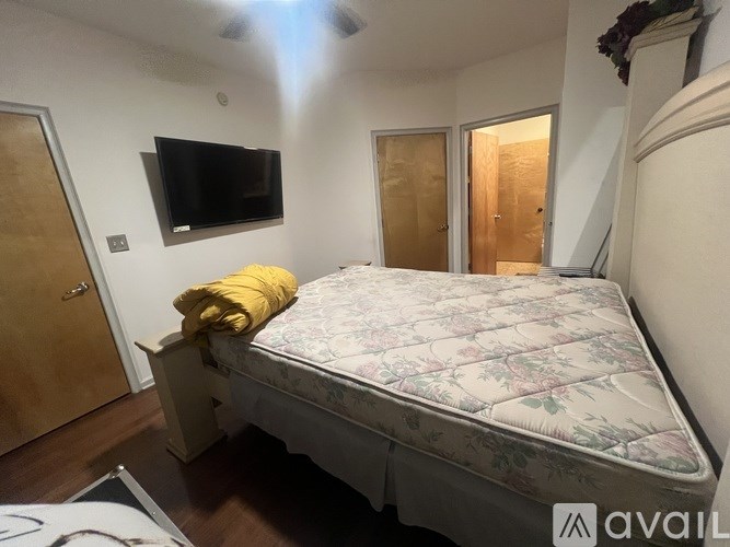 A bedroom with a bed, a television, and a door.