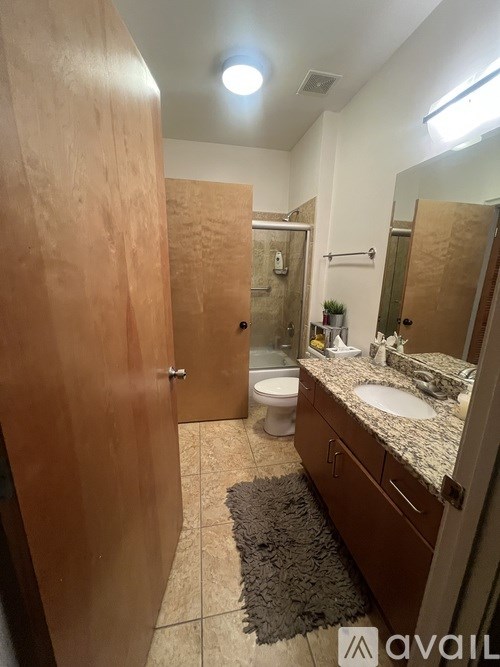 A bathroom with a toilet, sink, and mirror.