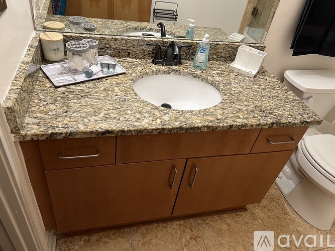 A bathroom with a granite countertop and a white sink.