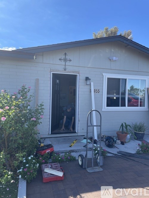 A house numbered 855 with a white door and a cross on the wall.