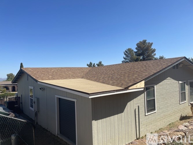 A house with a brown roof and a grey siding.