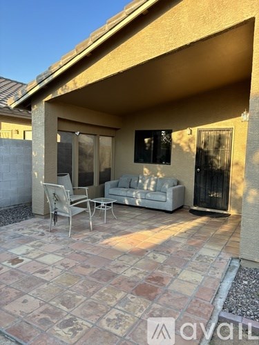 A patio with a couch, chairs, and a fireplace.