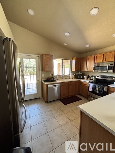 A kitchen with a refrigerator, microwave, and oven.