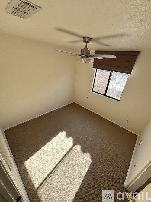 A room with a ceiling fan and a window.