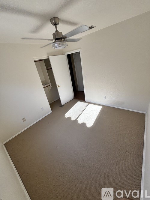 A room with a ceiling fan and a carpeted floor.