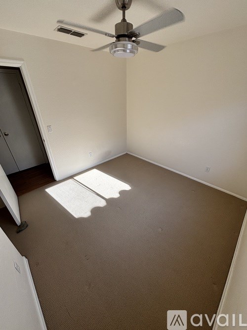 A room with a ceiling fan and a door.