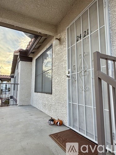 A house numbered 24 21 with a brown mat in front.