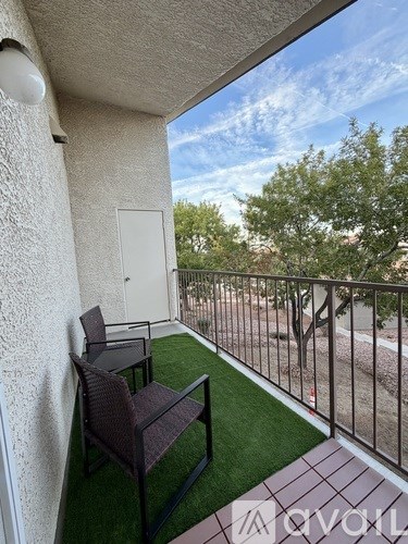 A balcony with two chairs and a table.
