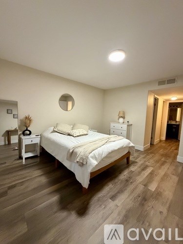 A bedroom with a bed, nightstand, and lamp.