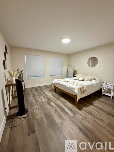 A bedroom with a bed, nightstand, and a television.