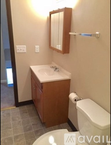 A bathroom with a sink, toilet, and mirror.