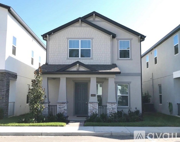 A two-story house with a grey front door and a small porch.