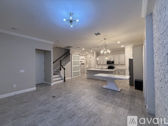 A spacious living room with a staircase and a dining area.