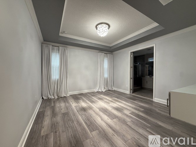 A room with wooden flooring and a ceiling light.