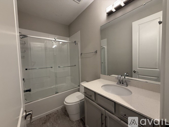 A bathroom with a toilet, sink, and shower.