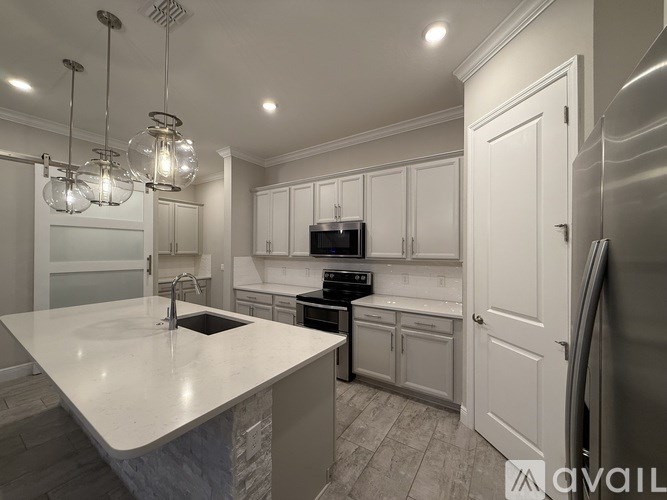 A modern kitchen with white cabinets and a large island.