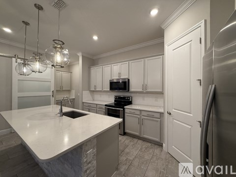 A modern kitchen with white cabinets and a large island.
