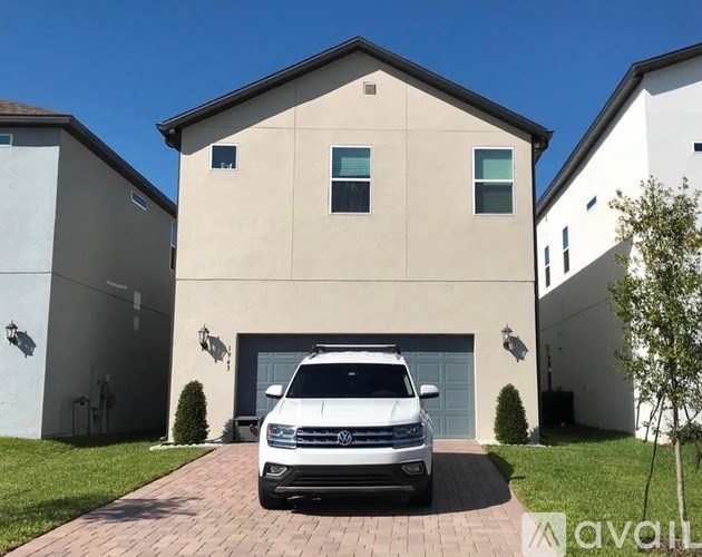 A white SUV is parked in front of a two-story house.