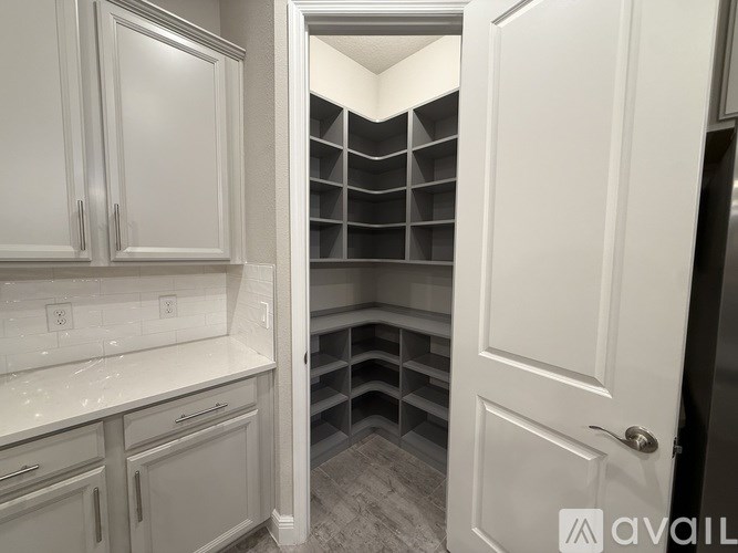 A kitchen with white cabinets and a white door.