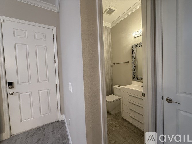 A bathroom with a toilet, sink, and mirror.