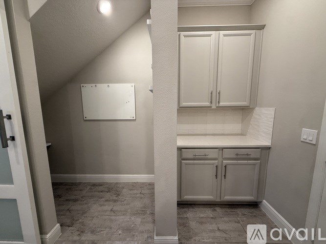 A white cabinet with a white countertop is in a room with a white wall.