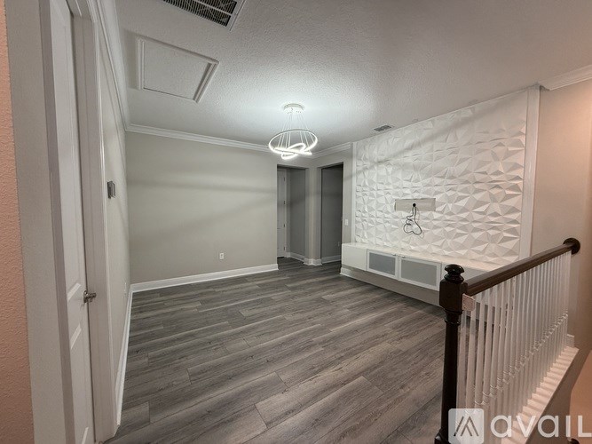 A room with a white wall and a wooden floor.