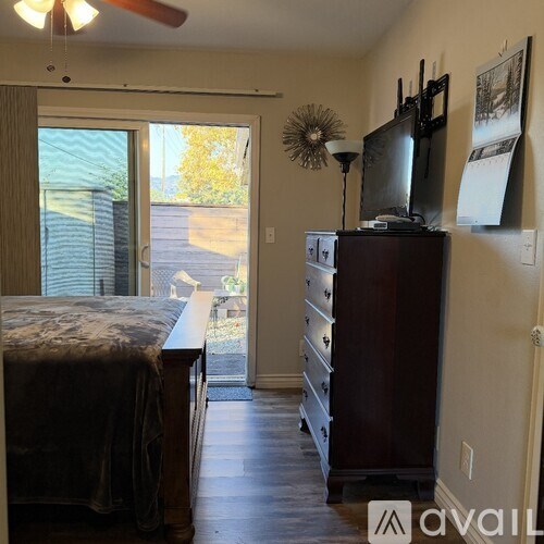A bedroom with a bed, dresser, and a television on top of the dresser.