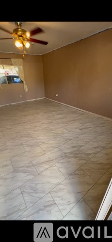 A room with a ceiling fan and a window.