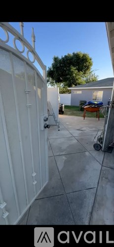 A white gate with a metal handle is open.