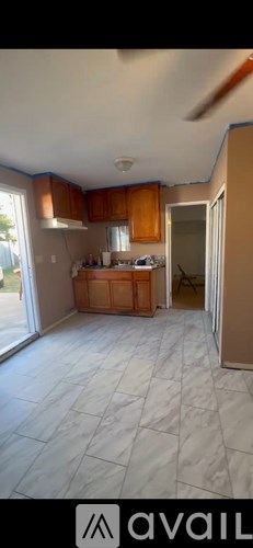 A kitchen with wooden cabinets and a tiled floor.