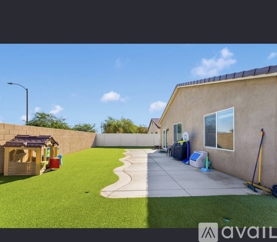 A backyard with a playhouse and a clean patio area.
