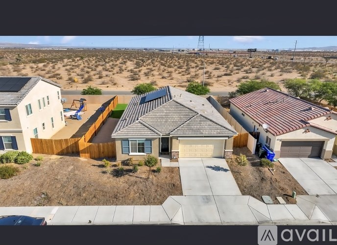 A house with a brown roof and a garage is surrounded by a brown fence.