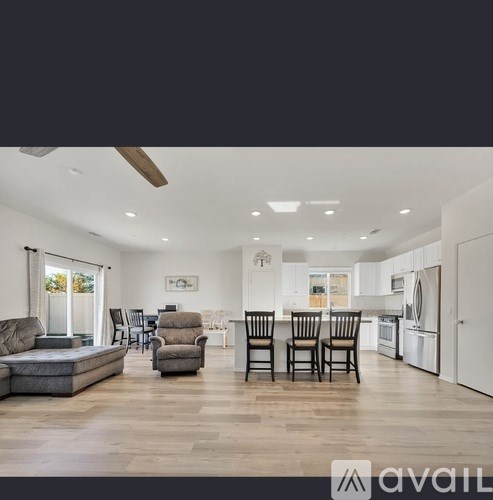 A well-lit, spacious kitchen and living room with modern furniture.