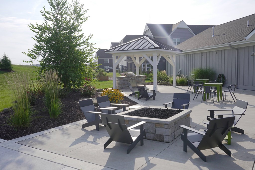 A patio with a table and chairs is surrounded by a garden.